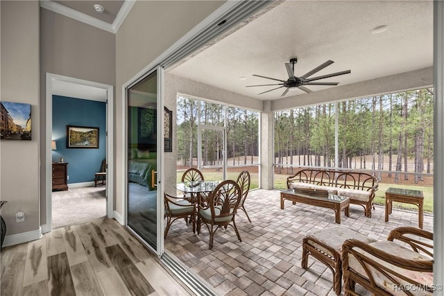 sunroom / solarium featuring ceiling fan