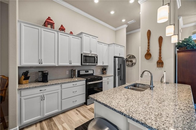 kitchen with ornamental molding, stainless steel appliances, decorative light fixtures, and sink