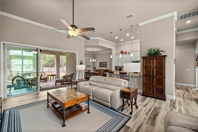 living room with crown molding, ceiling fan, and light wood-type flooring