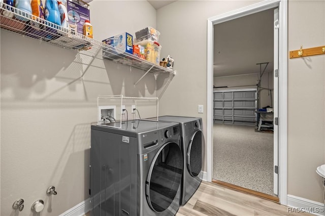 washroom with washer and clothes dryer and light hardwood / wood-style floors