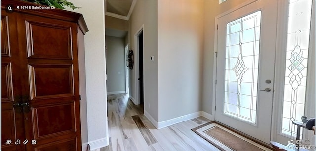 foyer entrance with ornamental molding and light hardwood / wood-style flooring