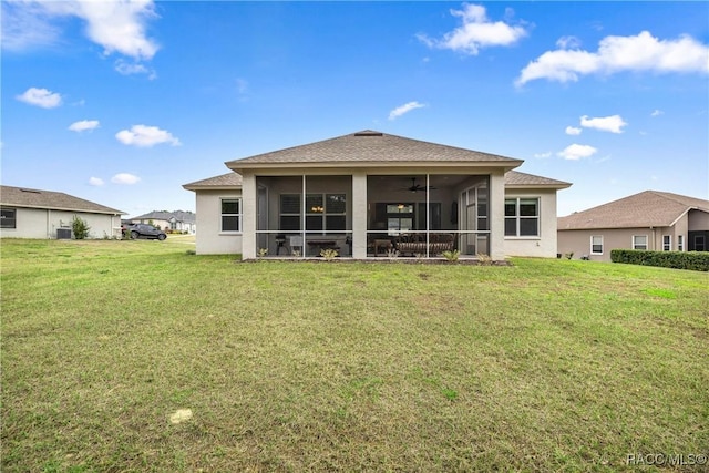 rear view of house featuring a lawn and a sunroom