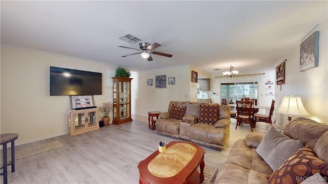 living area featuring light wood-type flooring, a textured ceiling, visible vents, and ceiling fan with notable chandelier