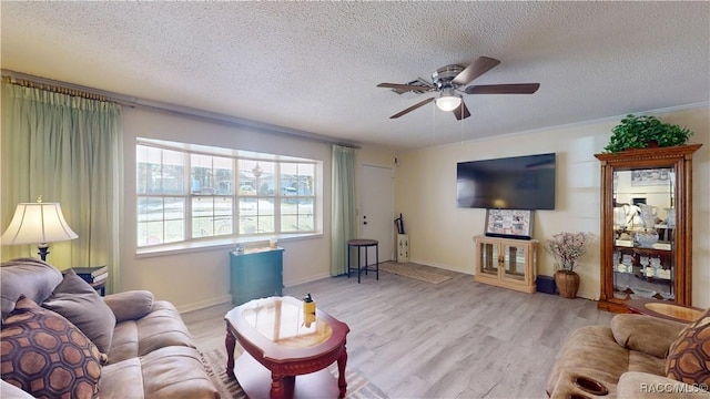 living room with a ceiling fan, baseboards, light wood finished floors, and a textured ceiling