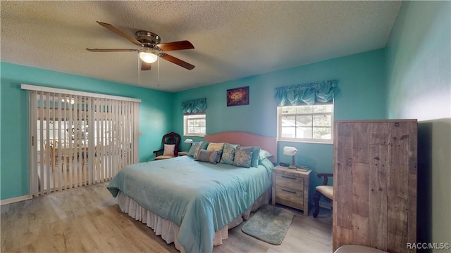 bedroom with a textured ceiling, ceiling fan, and wood finished floors