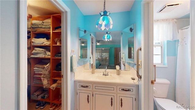 full bath with vanity, visible vents, ceiling fan, a spacious closet, and toilet