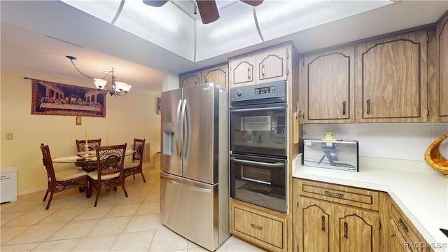 kitchen featuring stainless steel fridge with ice dispenser, light countertops, light tile patterned floors, ceiling fan with notable chandelier, and dobule oven black