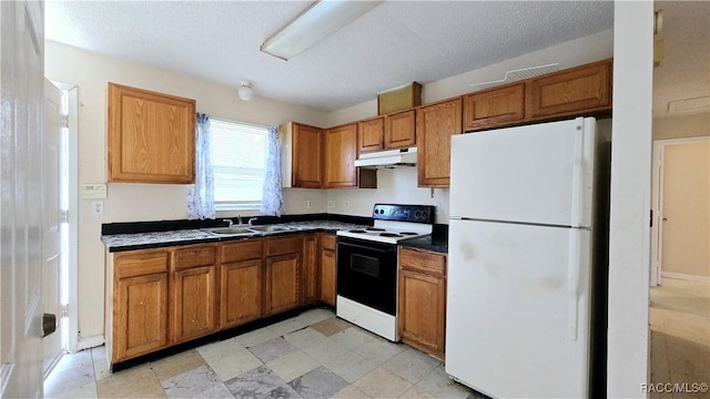 kitchen featuring a textured ceiling, white appliances, and sink