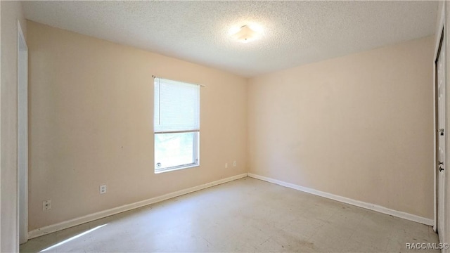 unfurnished room featuring a textured ceiling