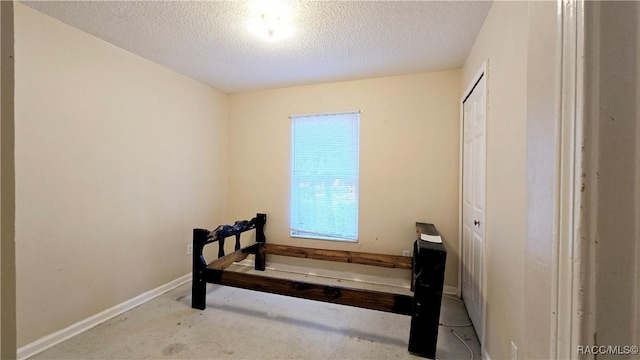 bedroom with a textured ceiling and a closet