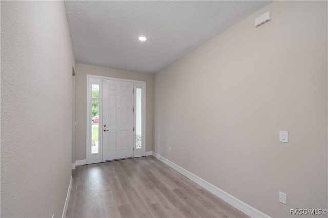 entryway featuring light hardwood / wood-style floors and a textured ceiling