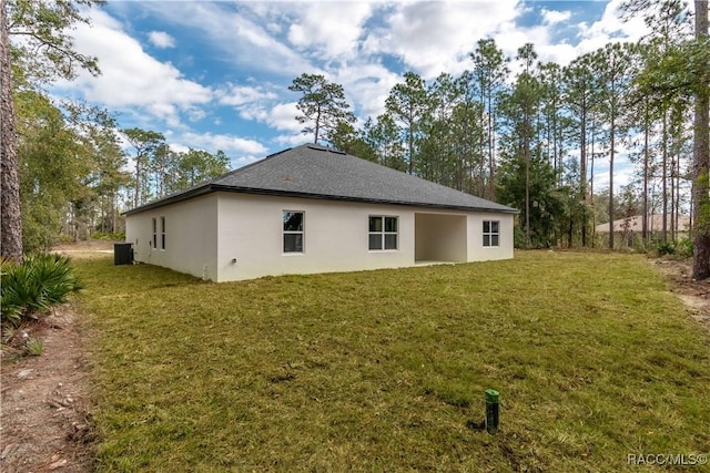 back of house featuring a yard and central AC