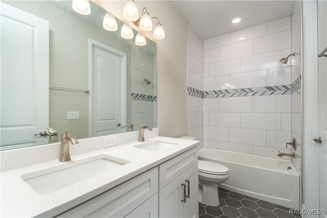 full bathroom featuring vanity, tile patterned flooring, tiled shower / bath combo, and toilet