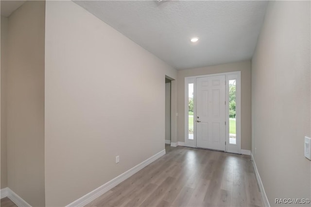 foyer featuring light hardwood / wood-style floors and a textured ceiling