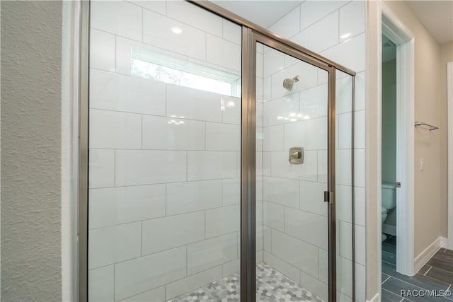 bathroom with toilet and an enclosed shower