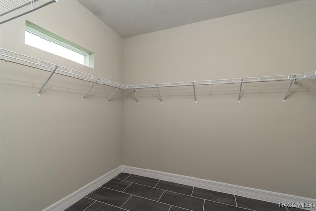 spacious closet with dark tile patterned floors