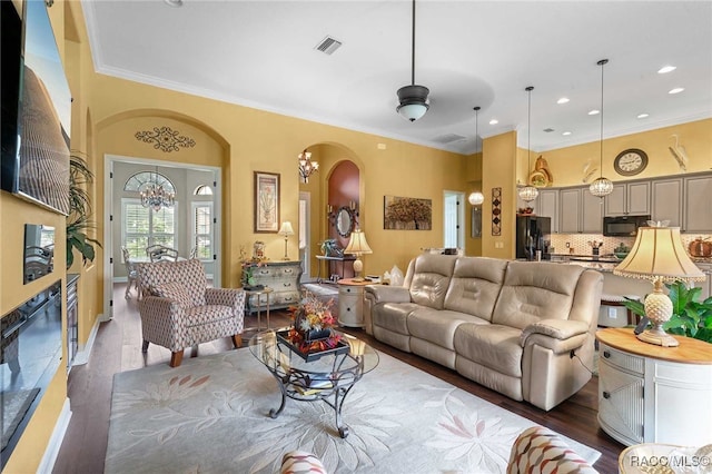 living room with dark hardwood / wood-style floors and crown molding