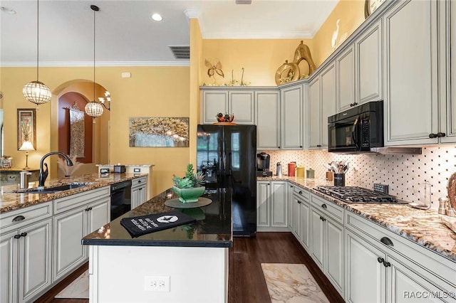 kitchen featuring sink, dark stone countertops, a kitchen island, black appliances, and ornamental molding