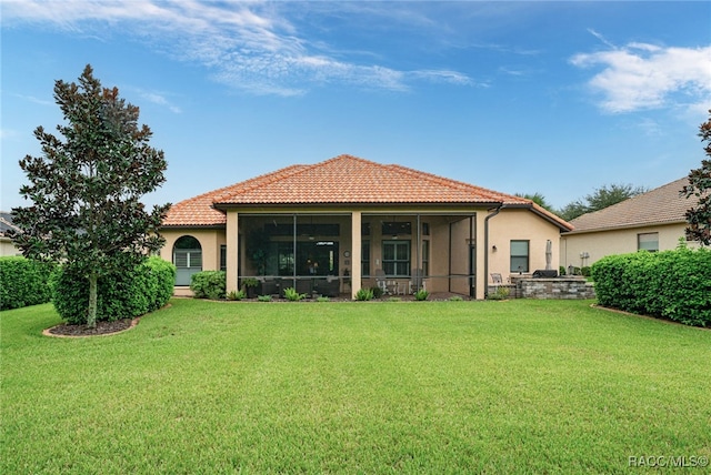 back of house with a sunroom and a lawn