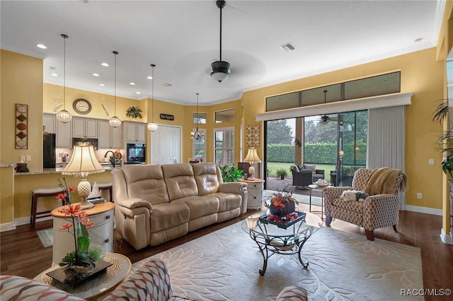 living room with ceiling fan, dark hardwood / wood-style flooring, and crown molding