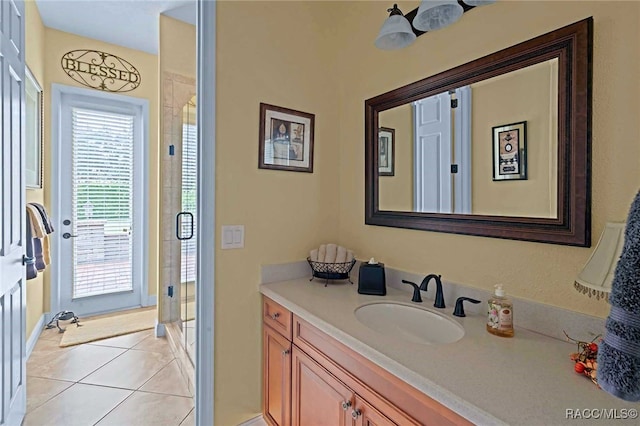 bathroom with plenty of natural light, vanity, an enclosed shower, and tile patterned flooring