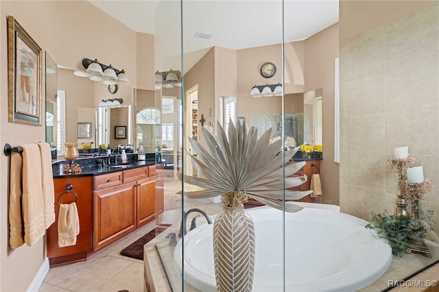 bathroom featuring tile patterned floors, tiled tub, and vanity