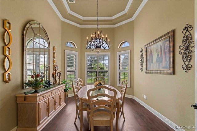 dining space featuring a chandelier, dark hardwood / wood-style floors, a tray ceiling, and ornamental molding