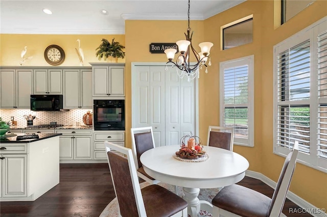 dining area with dark hardwood / wood-style floors, crown molding, and an inviting chandelier