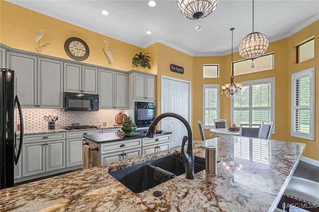 kitchen with sink, gray cabinets, a notable chandelier, and black appliances