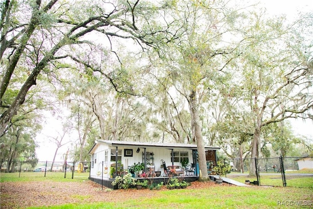 view of front of home with covered porch, a front lawn, and fence