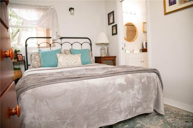 bedroom with baseboards and ensuite bath