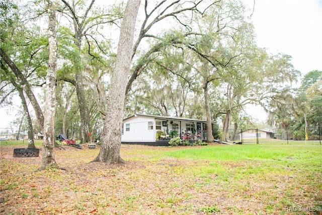 view of yard featuring covered porch and fence