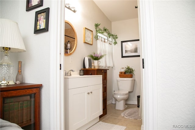 bathroom with tile patterned flooring, vanity, and toilet