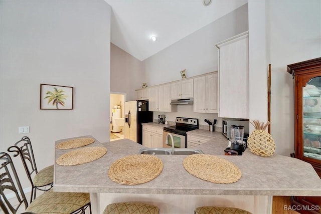 374 W Wason St, Citrus Springs, FL 34434 - kitchen with stainless steel range with electric cooktop, high vaulted ceiling, refrigerator with ice dispenser, light countertops, and a kitchen breakfast bar