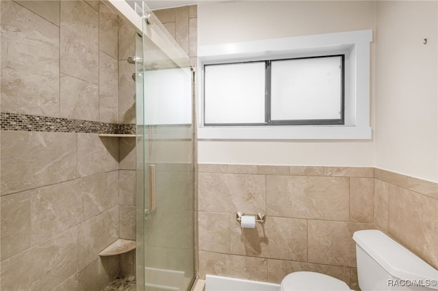 full bathroom with a shower stall, toilet, and tile walls