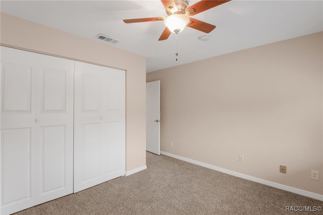 unfurnished bedroom featuring carpet, visible vents, baseboards, ceiling fan, and a closet