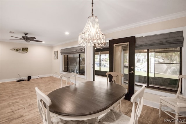 dining area featuring wood finished floors, visible vents, baseboards, ornamental molding, and ceiling fan with notable chandelier