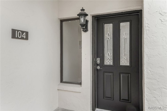 entrance to property with stucco siding