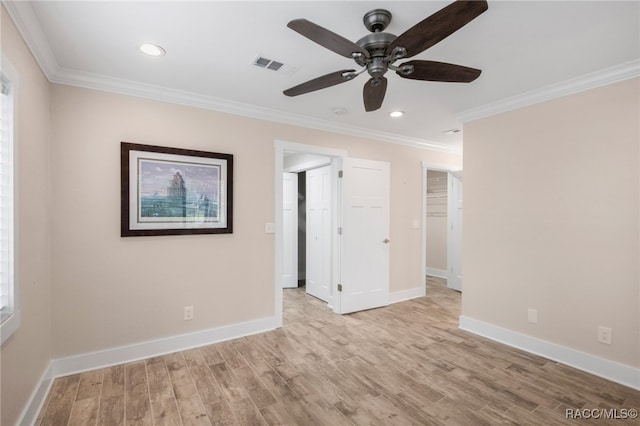 unfurnished bedroom with crown molding, baseboards, visible vents, and light wood finished floors