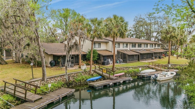 view of dock featuring a lawn and a water view