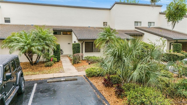 view of property with stucco siding and uncovered parking