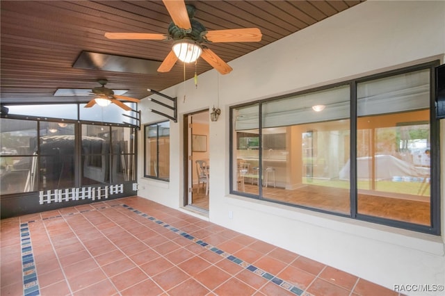 unfurnished sunroom with wood ceiling and ceiling fan