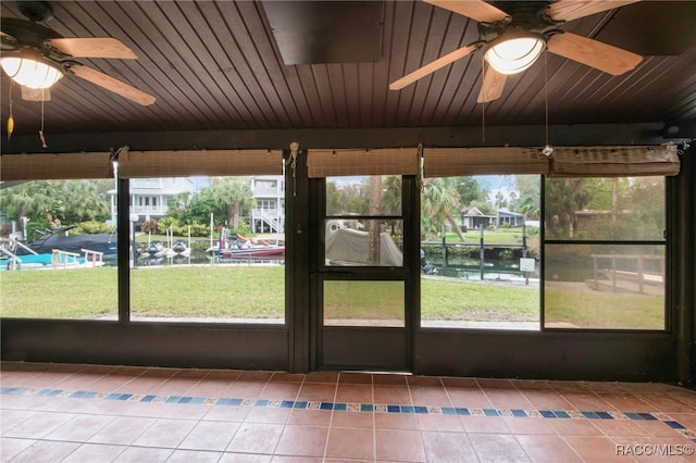 unfurnished sunroom featuring wood ceiling and a ceiling fan