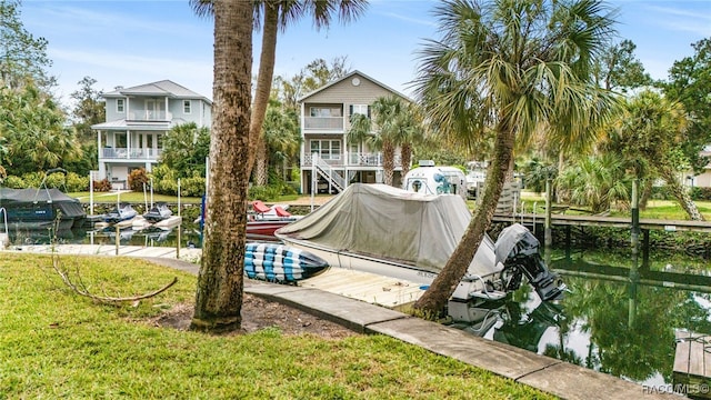 surrounding community featuring a lawn and a boat dock