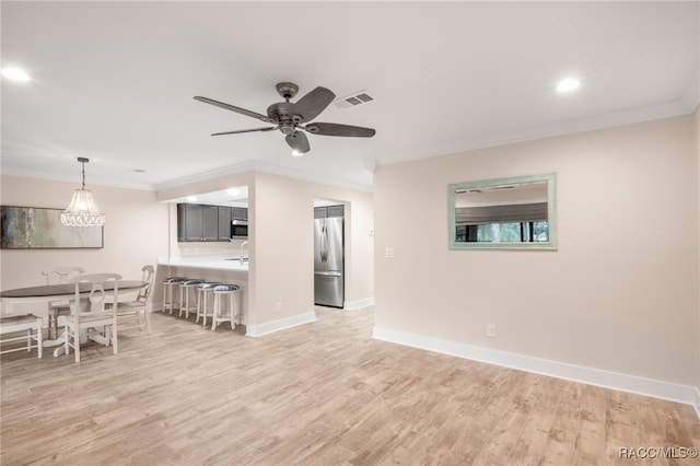 unfurnished living room featuring light wood-style flooring, baseboards, visible vents, and ornamental molding