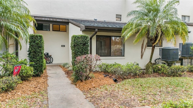 entrance to property featuring central air condition unit and stucco siding