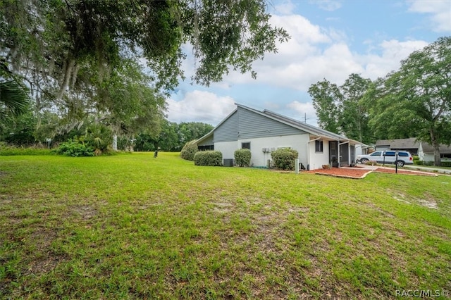 view of side of home with a yard