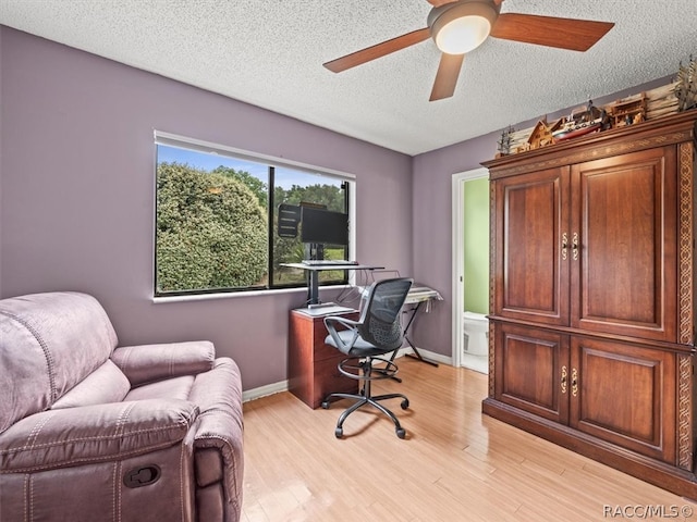 office featuring ceiling fan, light hardwood / wood-style floors, and a textured ceiling