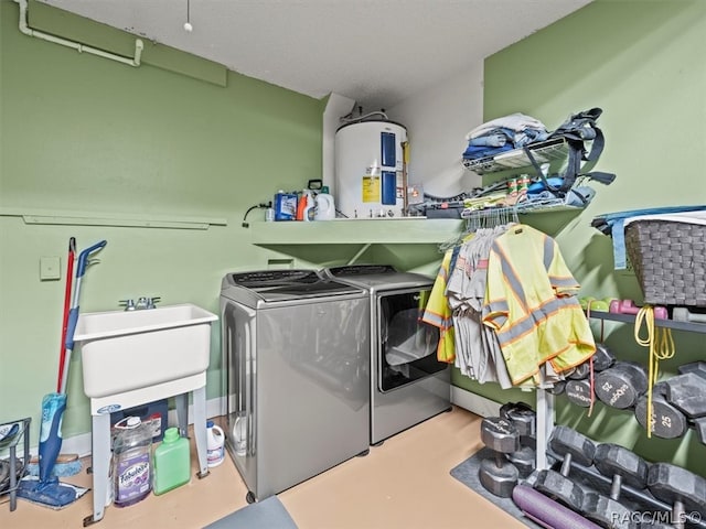 clothes washing area with washer and dryer, electric water heater, and sink