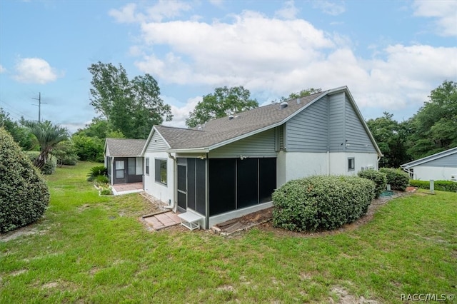 rear view of property with a sunroom and a lawn